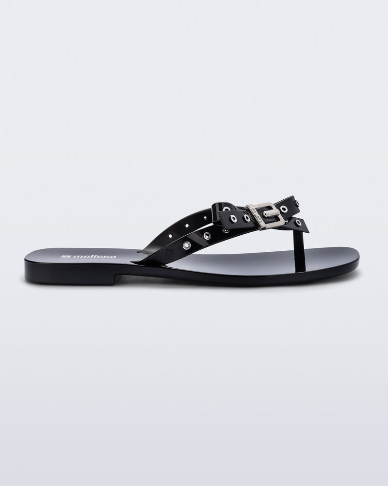 Side view of a black Harmonic Squared flip flop with bow on strap