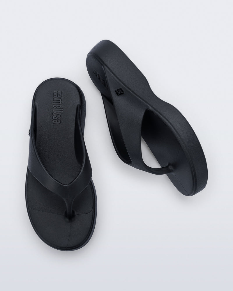 Top and side view of a pair of black Free Thong Low Flip Flops