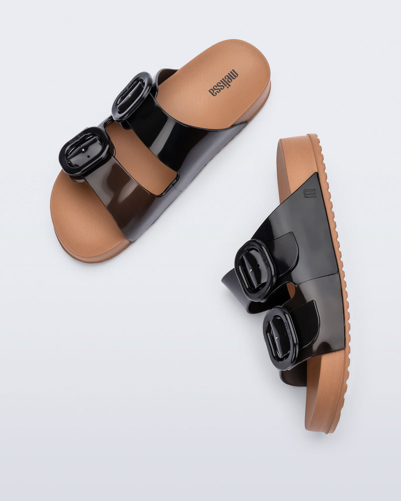 Top and side view of a pair of black Cozy slides with beige soles