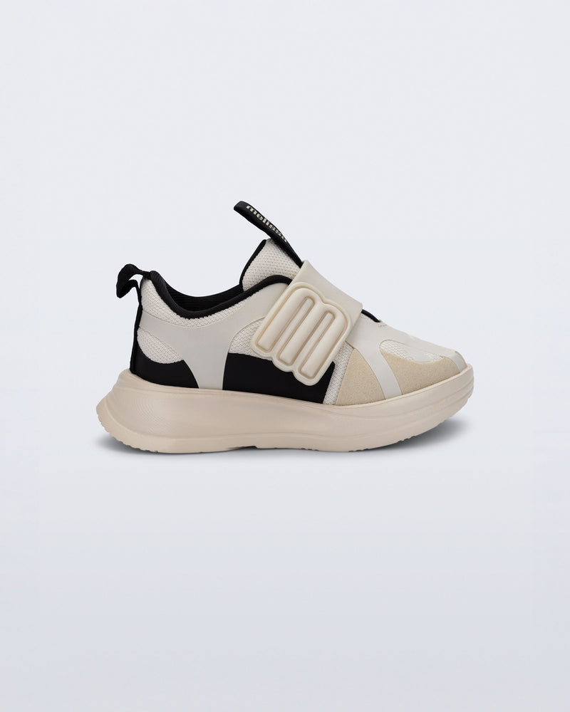 Side view of an off white X Beat baby sneaker with black trim