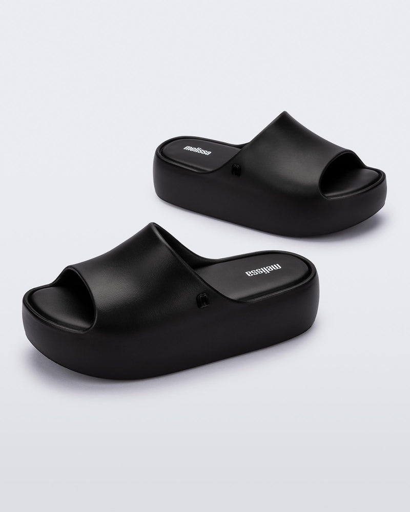 Angled view of a pair of black Free Platform women's slides