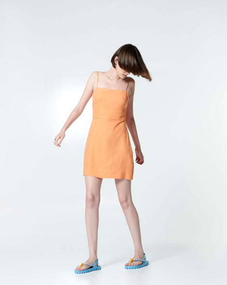 Model in a orange dress wearing a pair of blue Bond sandals with textile strap and orange toe piece