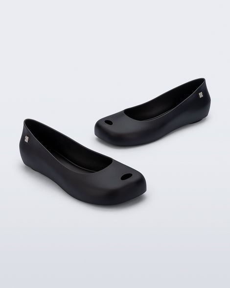 Angled view of a pair of black Ultragirl Futura ballerina flats