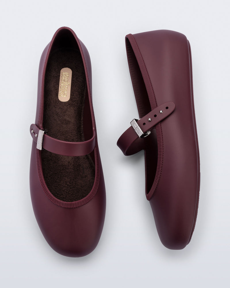 Top and side view of a pair of burgundy Soft Ballerina flats with top strap and silver buckle