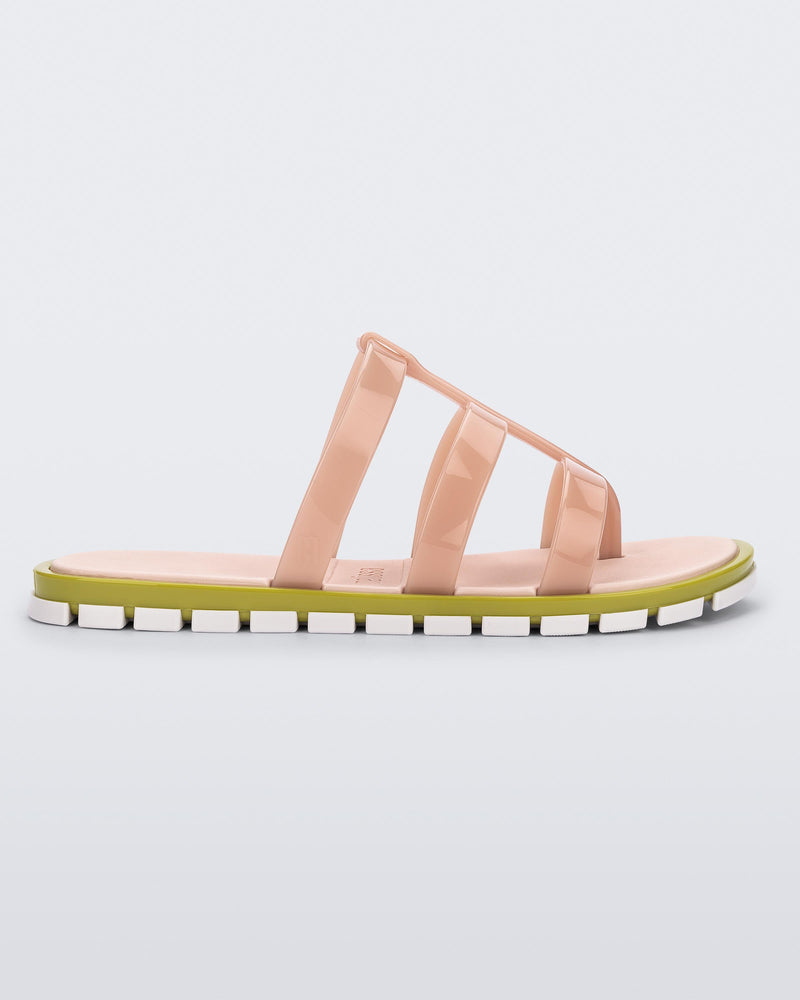 Side view of a pink Path adult sandal with green sole