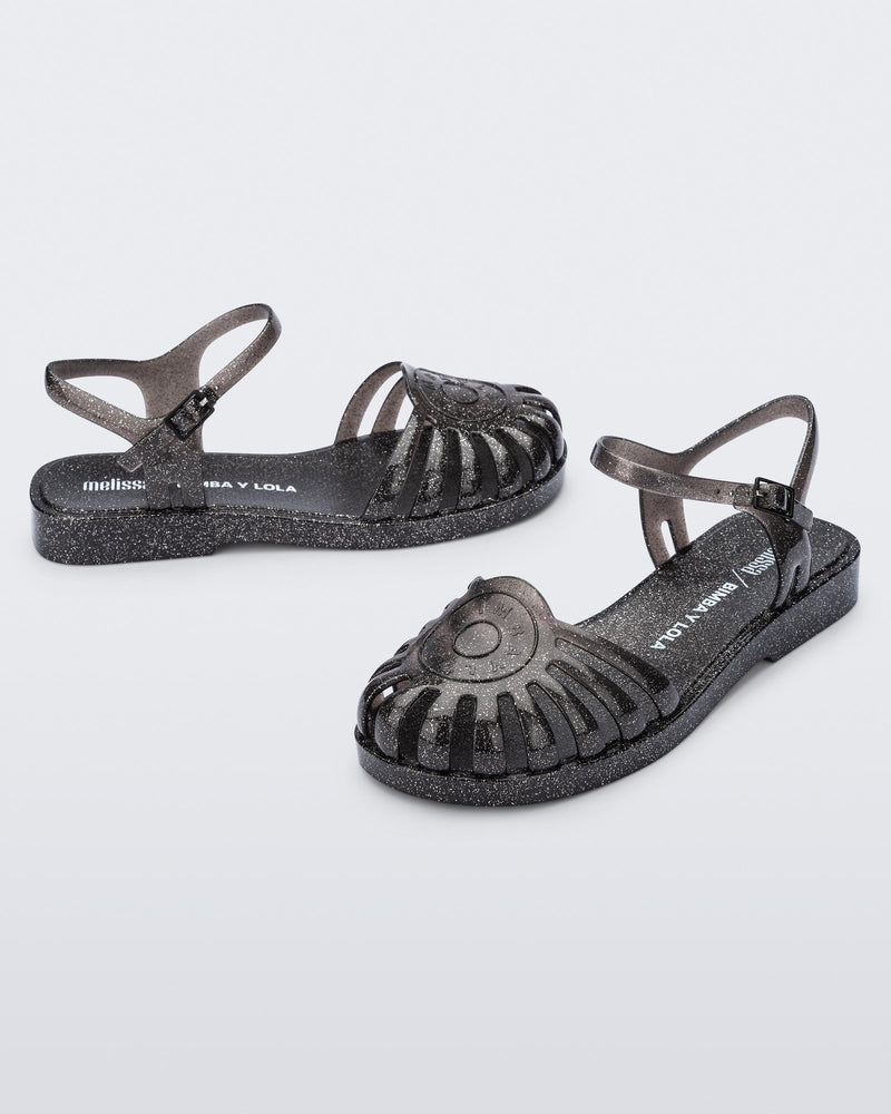 Angled view of a pair of the glitter black Sandal + Bimba y Lola with ankle strap