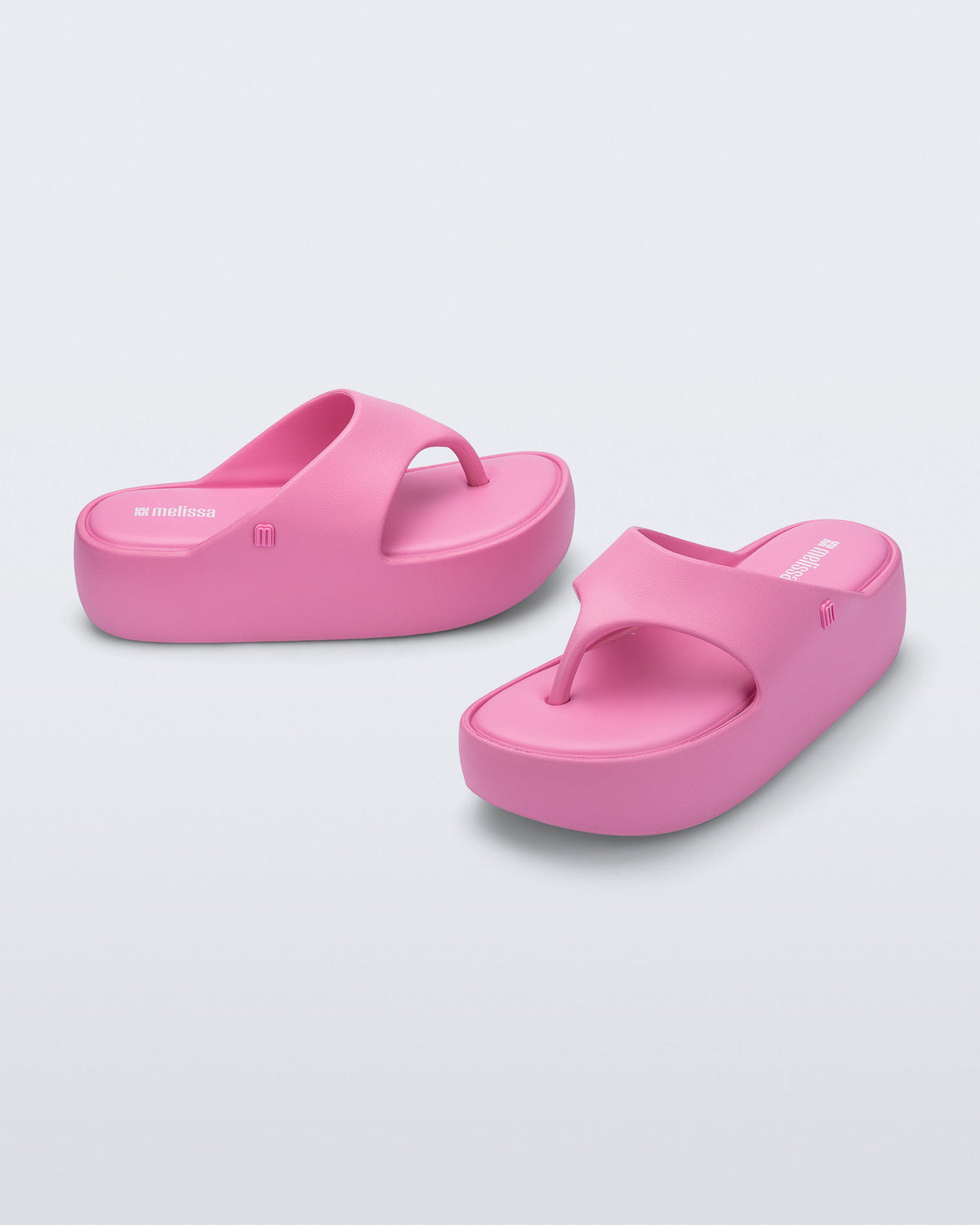 Side and angled view of a pair of pink Free Platform Thong sandals