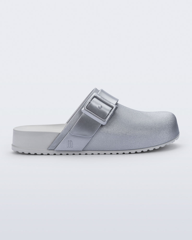 Side view of a silver Cozy Clog with buckle decoration