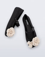 Model's legs wearing a pair of black Soft ballerina Petals flats with beige flowers