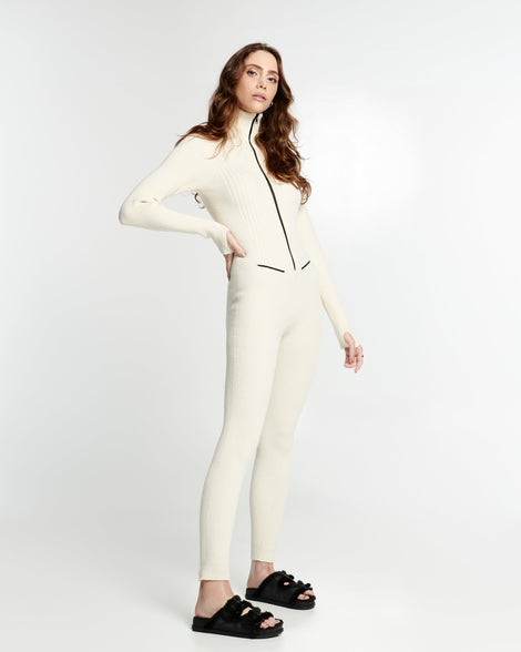 Model in a cream outfit wearing a pair of black Cozy Warm Slides with black fuzzy insoles