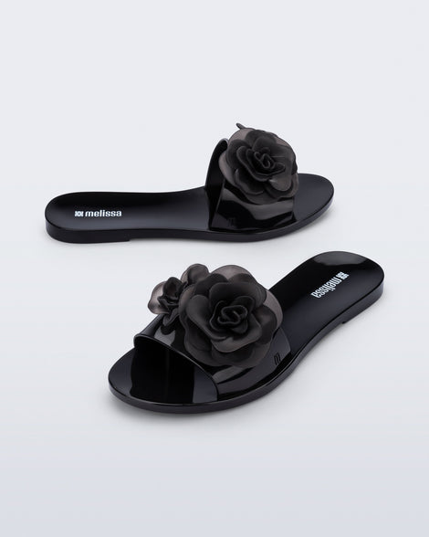 Side and angled view of a pair of black Babe Petals slide sandals