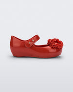 Side view of a red Ultragirl Springtime baby flat with two red flowers and peep toe.