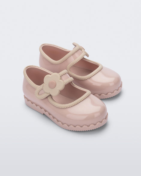 Side view of a pair of beige Hip Ballerina baby flats with strap with flower