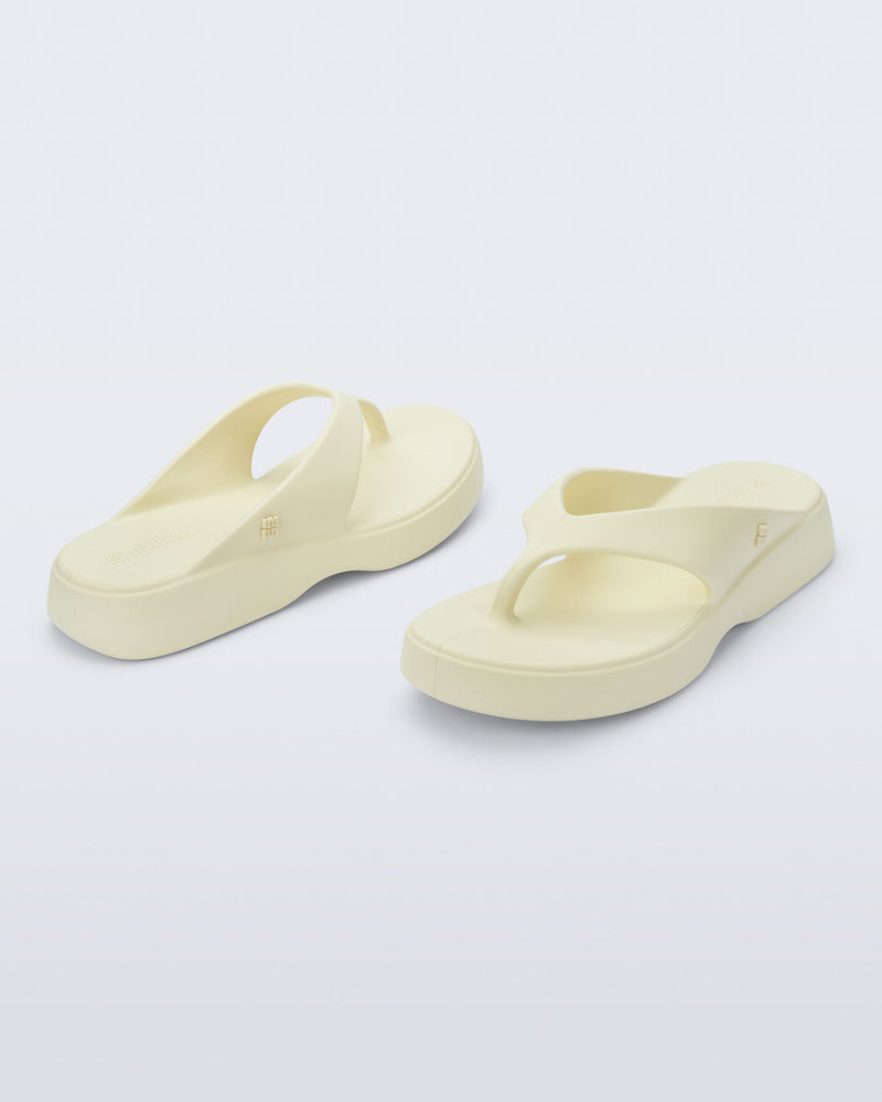 Angled view of a pair of beige Free Thong Low Flip Flops
