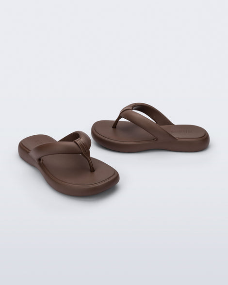 Side and angled view of a pair of bronze Free Low flip flops