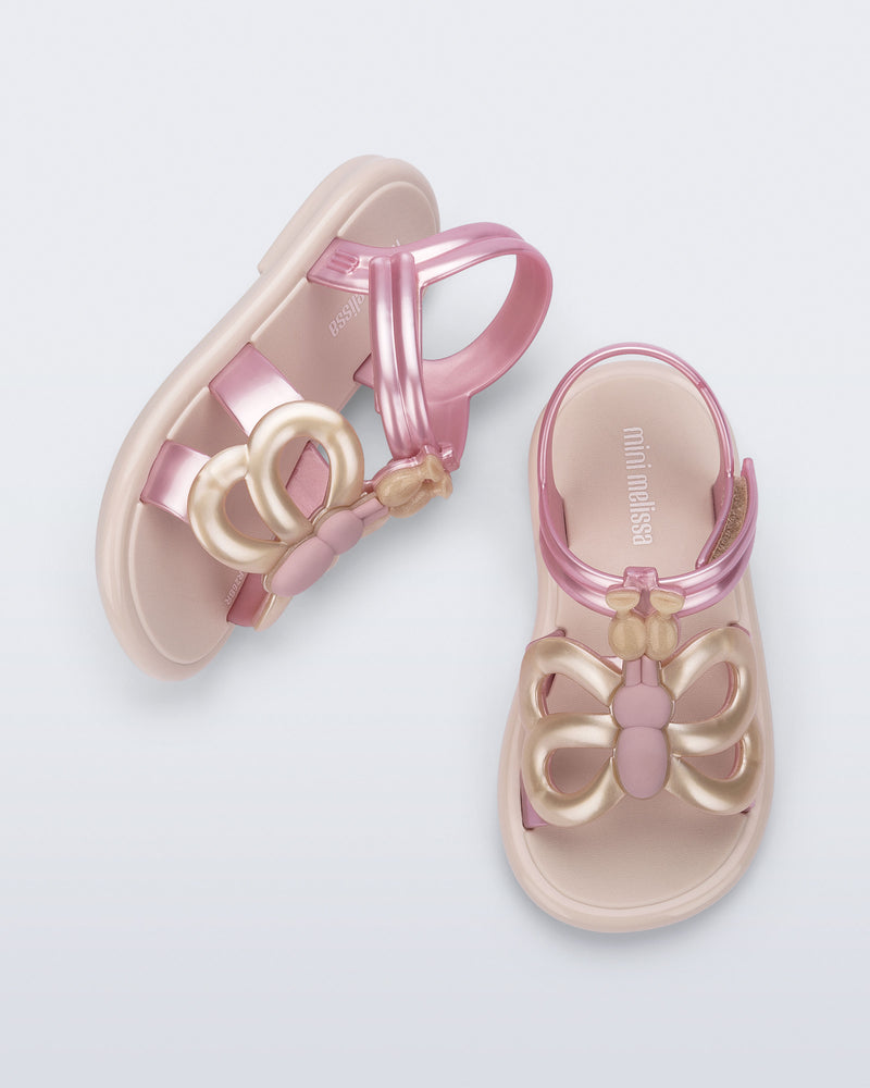 Side and angled view of a pair of pink strap, beige sole Hip Butterfly baby sandals
