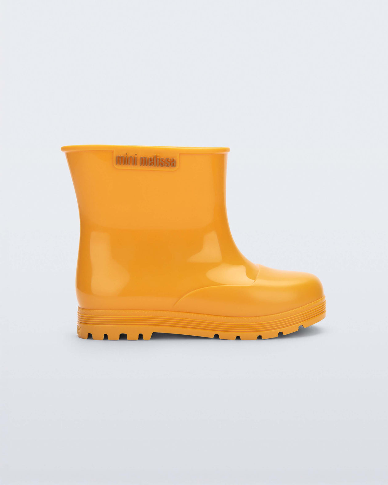 Side view of an orange Welly baby rainboot