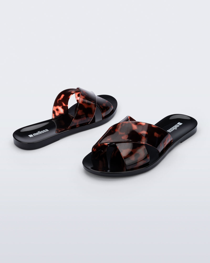 Back and angled view of a pair of black Essential Cross Slide sandals with tortoise colored straps