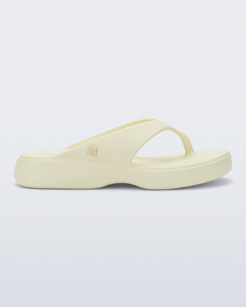 Side view of a beige Free Thong Low flip flop