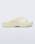 Side view of a beige Free Thong Low flip flop