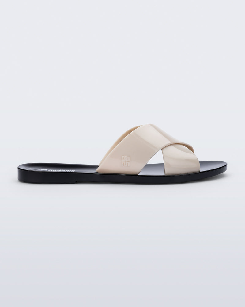 Side view of a black Essential Cross Slide sandal with beige colored straps