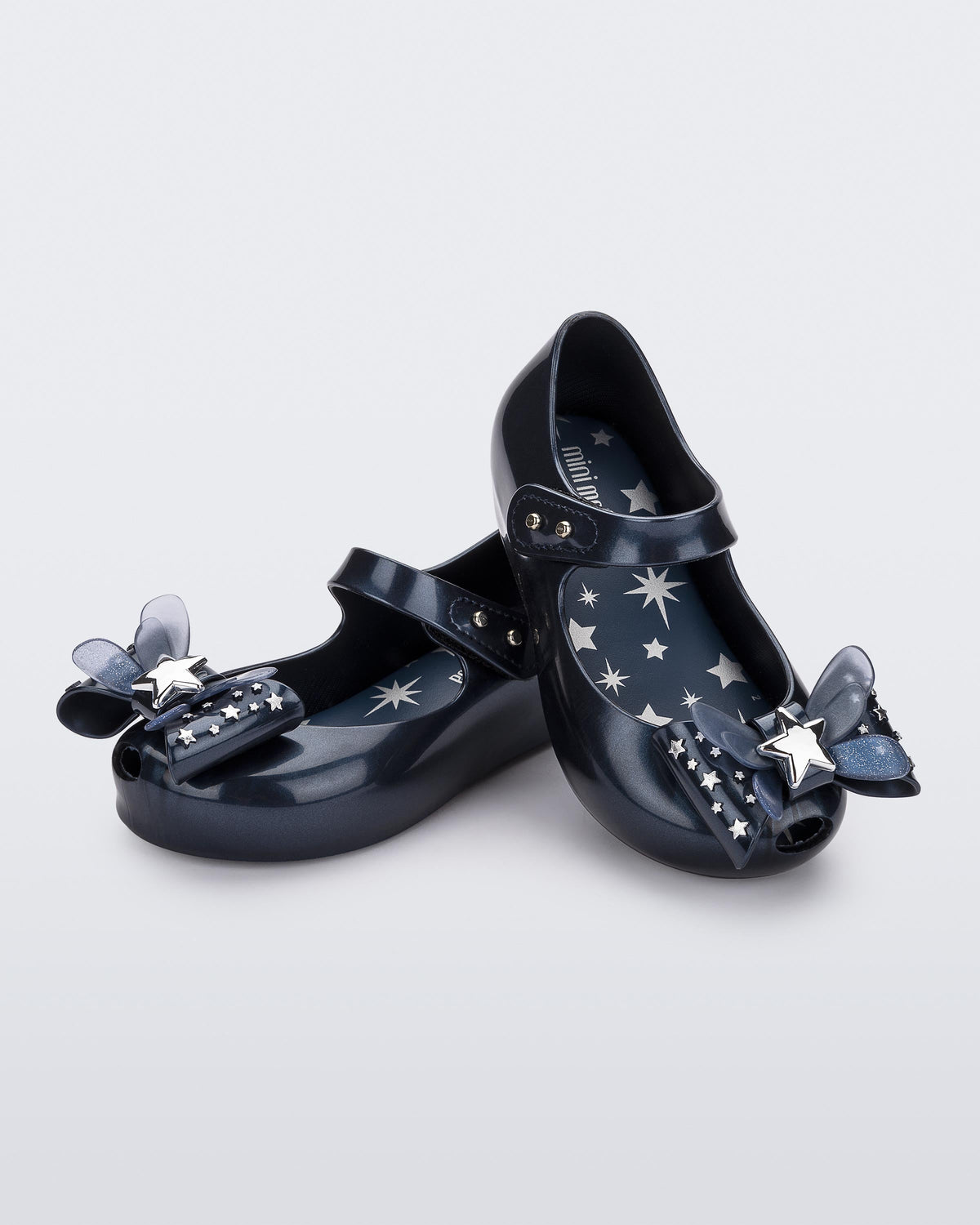 Angled view of a pair of Mini Melissa Ultragirl peeptoe ballet flats for baby in blue with star printed butterfly bow applique.