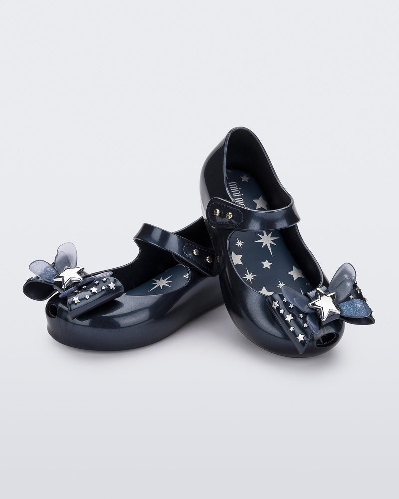 Angled view of a pair of Mini Melissa Ultragirl peeptoe ballet flats for baby in blue with star printed butterfly bow applique.