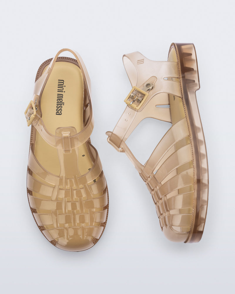 Side and top view of a pair of transparent beige Possession kids sandals