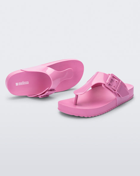 Top and angled view of a pair of pink Cozy Flip flops