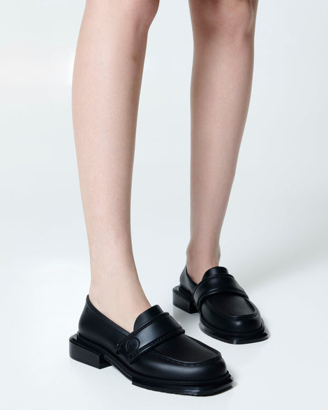 Model's legs wearing a pair of black Spencer loafers