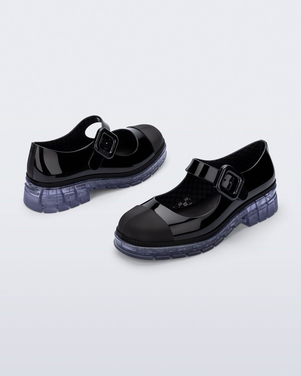 Back and side angle view of a pair of black with clear sole June mary janes with matte toe cap