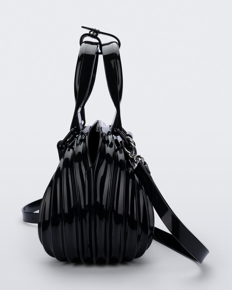 Side view of a black Quantum Dome + Diesel bag with hand strap and shoulder strap
