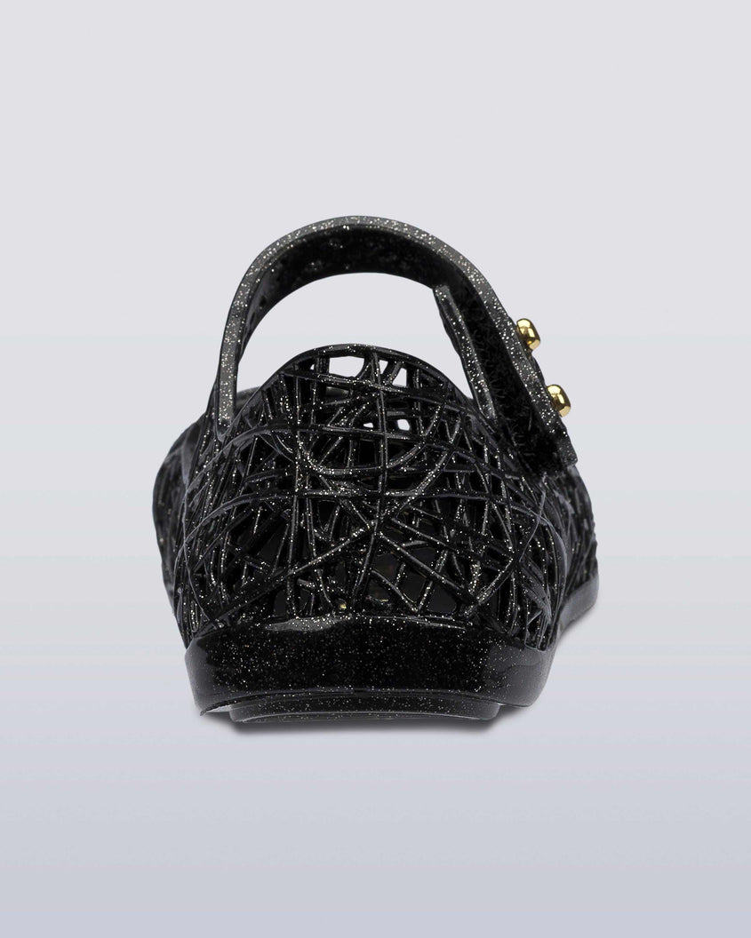 Back view of a Black/Silver Glitter Mini Melissa Campana Zig Zag flats with a top strap and a woven detail design.