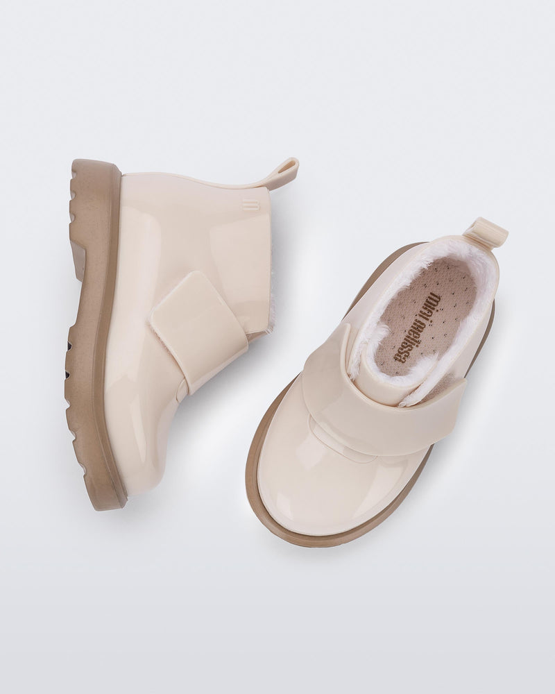 Top and side view of a pair of beige/brown baby Chelsea boots with faux fur lining