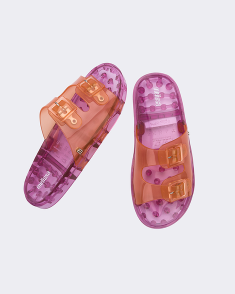 Top and angled view of a pair of Melissa Wide slide sandals with pink sole and two orange front straps