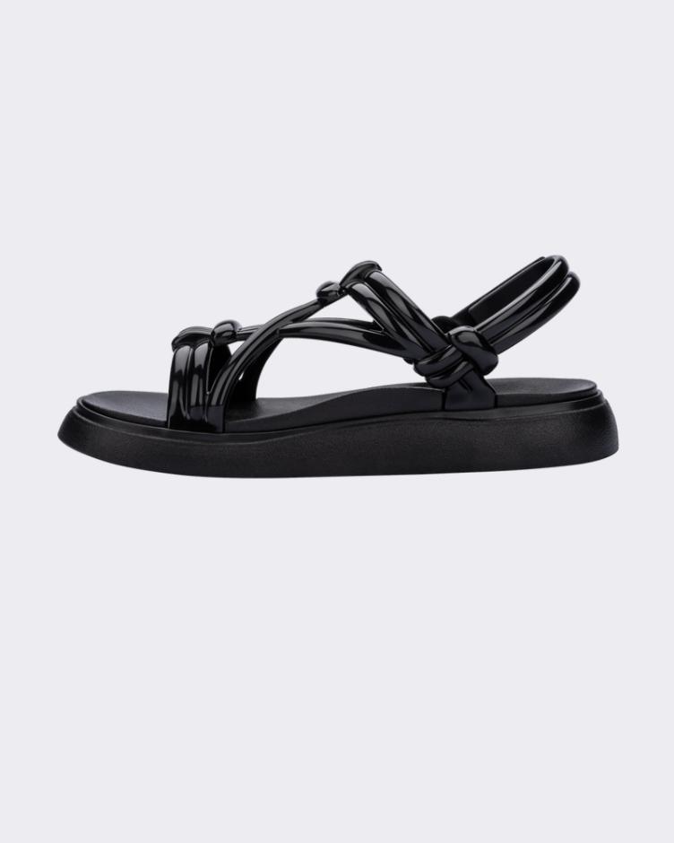 An inner side view of a black Melissa Papete Essential sandal with straps.