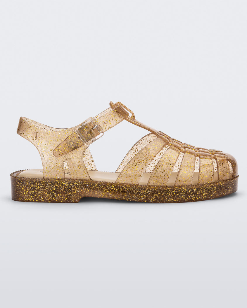Side view of a Beige/Glitter/Gold Mini Melissa Possession Shiny sandal with several straps and a gold glitter base.