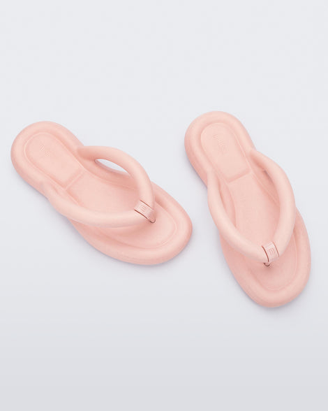 Top view of a pair of light pink Melissa Free Flip Flops with puffer-like straps.