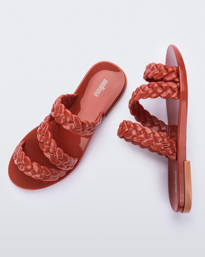 A top and side view of a pair of brown/beige Melissa Wrap slides with three braid like straps.
