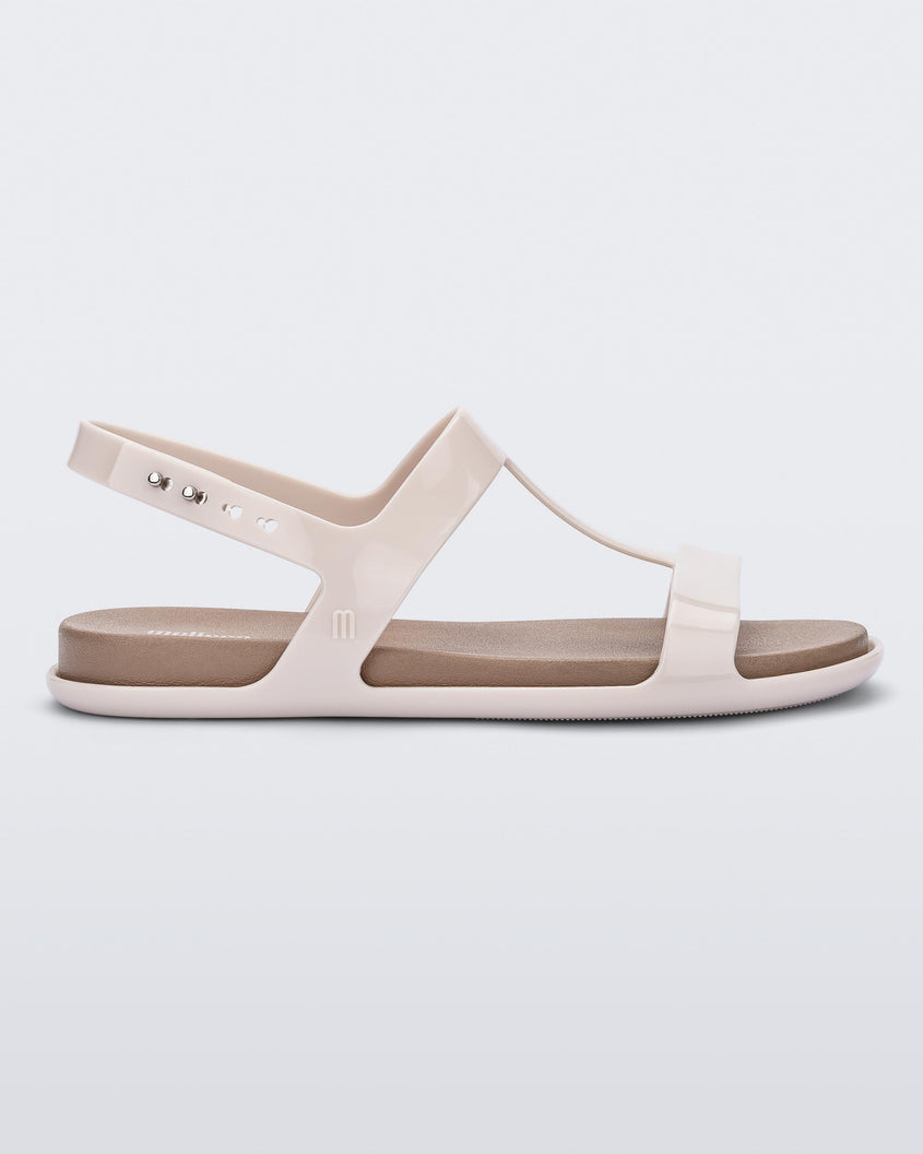 Side view of a beige / brown Melissa Adore sandal with two beige straps, joined together by a third strap and a brown insole.