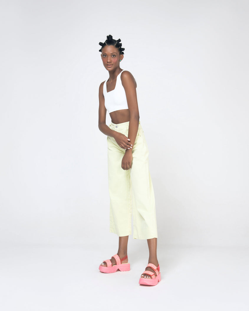 A model posing wearing a pair of pink Melissa Brave Platform sandals with flower print straps.