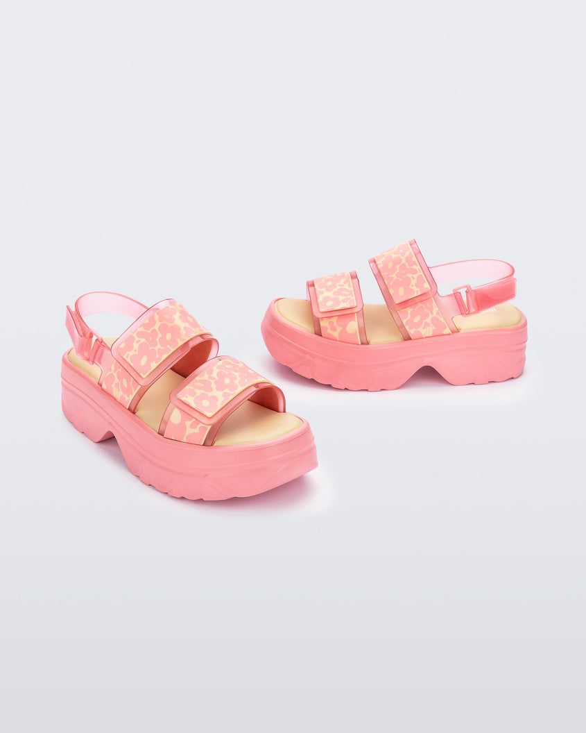 Angled view of a pair of pink Melissa Brave Platform sandals with flower printed straps.