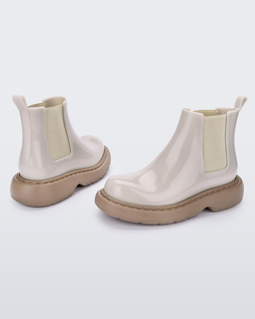 Angled view of a pair of Melissa Step slip on ankle boots with beige upper and brown lugg sole