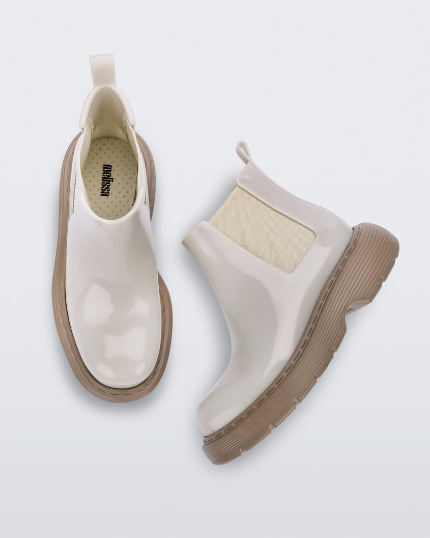Top and side view of a pair of Melissa Step slip on ankle boots with beige upper and brown lugg sole