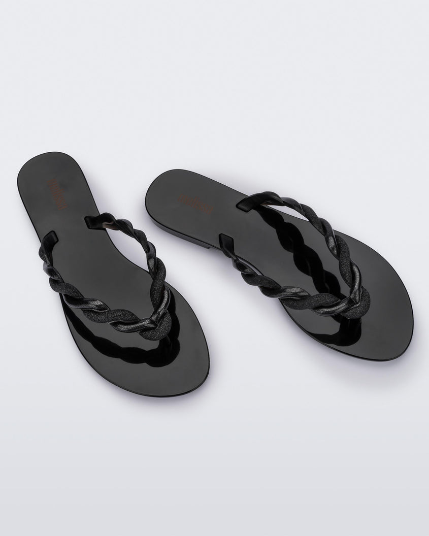 Top view of a pair of Black/Gold Melissa Louise Flip Flops with glitter twisted rope like straps.