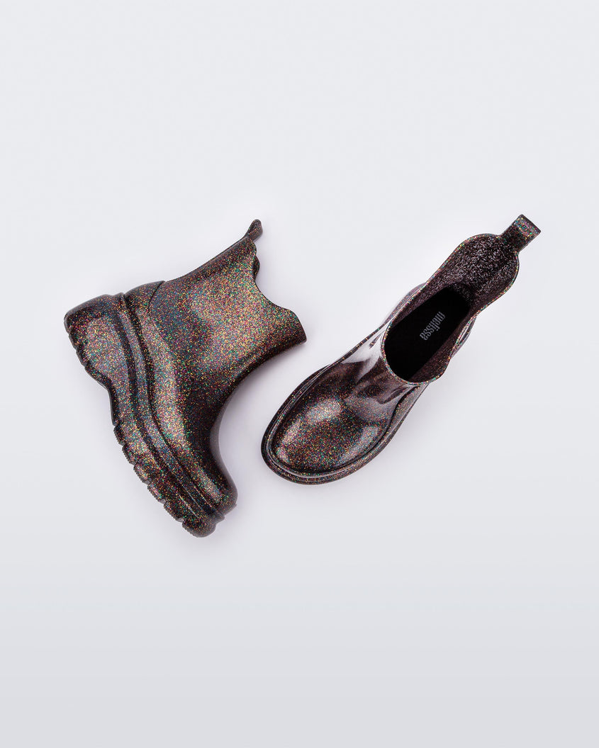 A side and top view of a pair of clear glitter Melissa Grip mutlicolor glitter short rain boots.