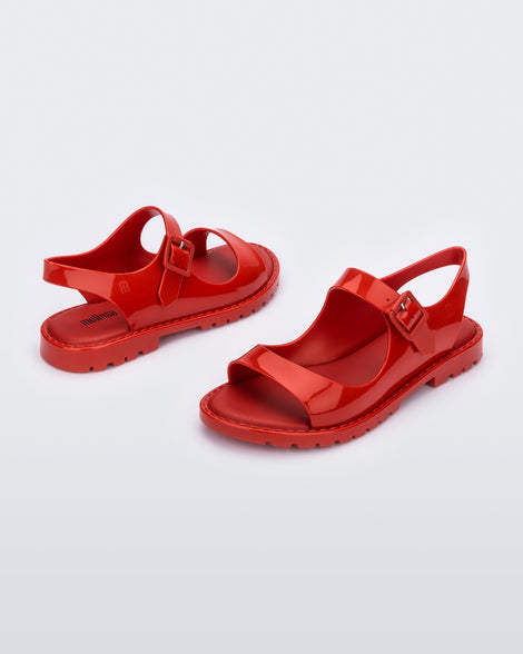 Angled view of a pair of red Melissa Bae sandals.