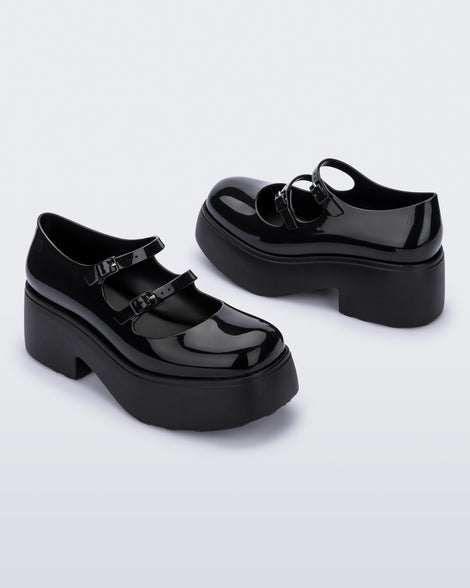 A side and back view of a pair of black Melissa Farah platforms with two top straps.