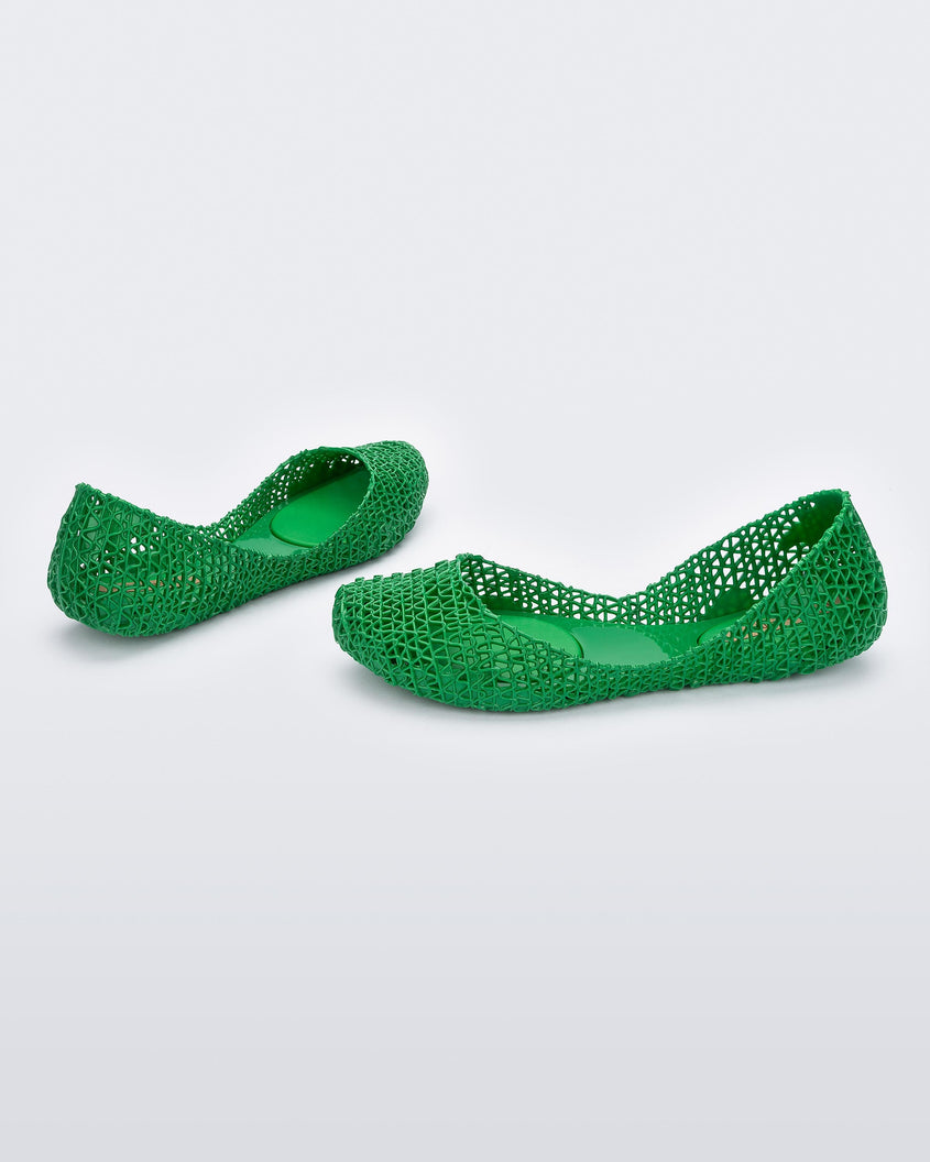 Angled view of a pair of Melissa Campana flats in green with an open woven texture.
