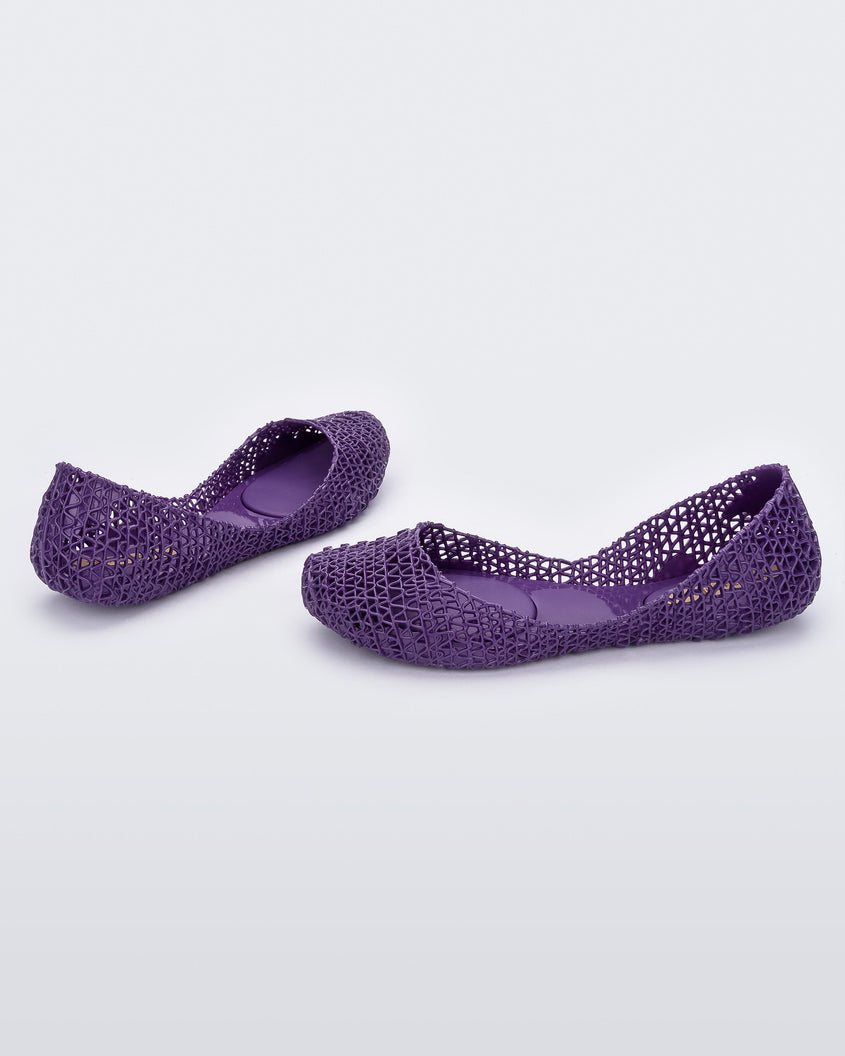 Angled view of a pair of Melissa Campana flats in purple with an open woven texture.